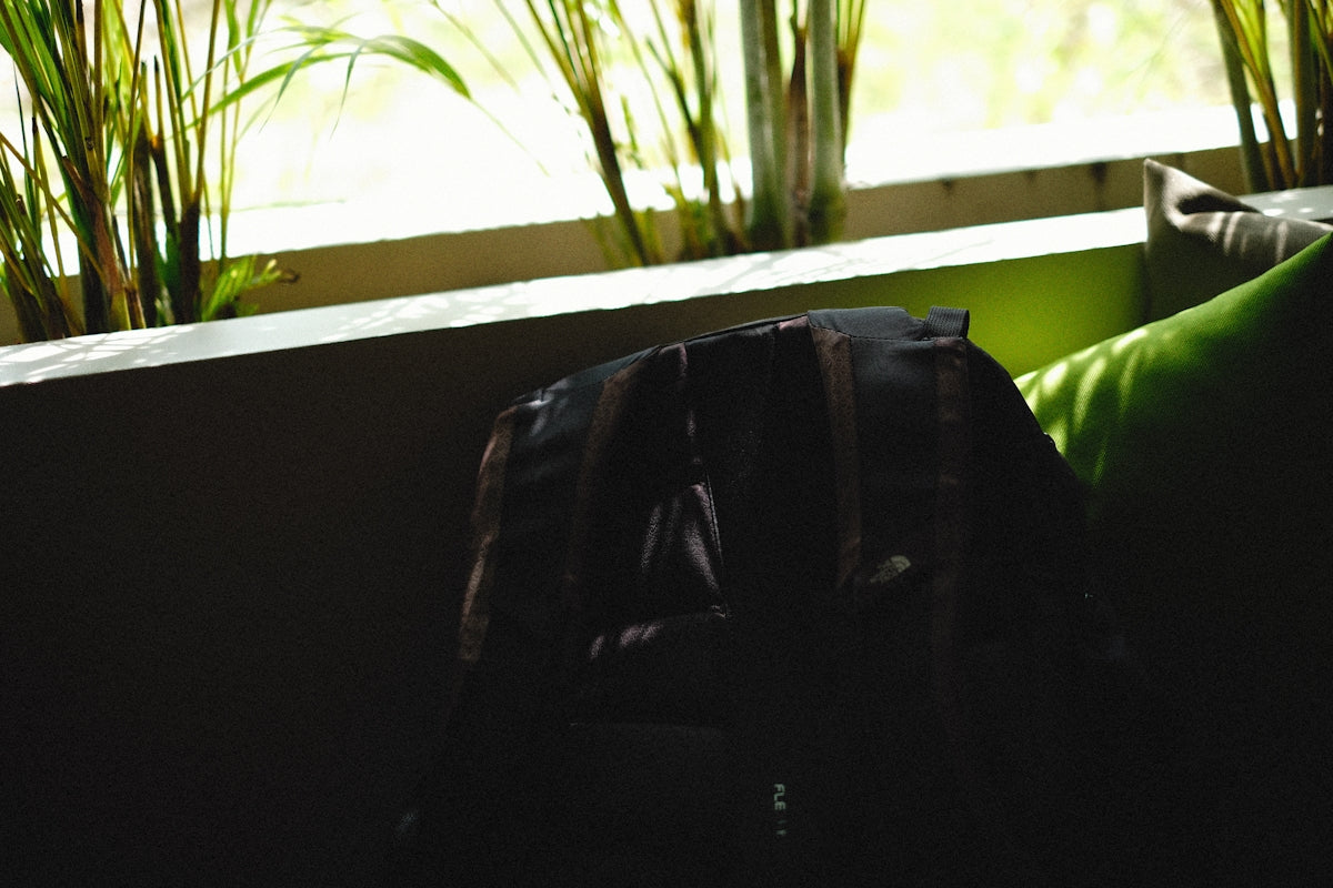 a black bag sitting on top of a green pillow