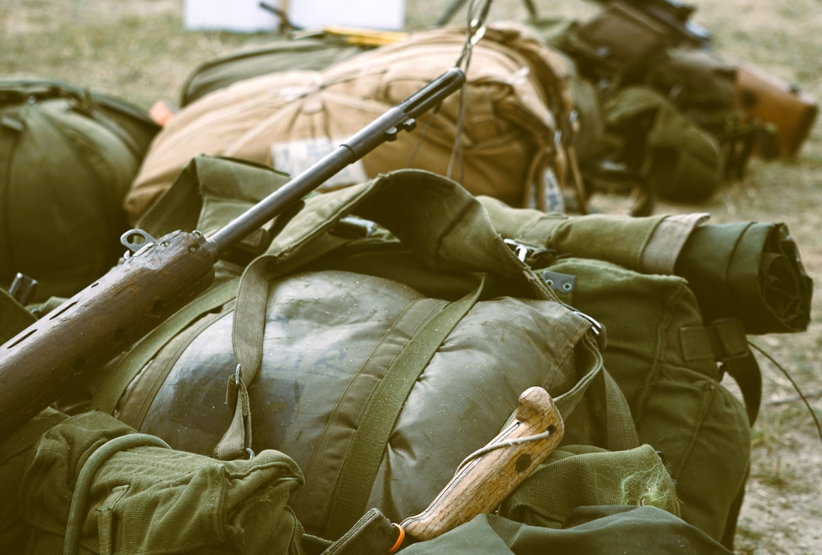 Military gear and parachute bags piled together.