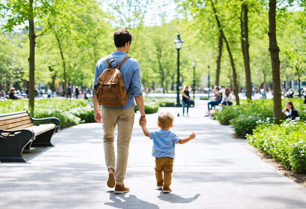 Father and son enjoying a walk in the park with durable canvas crossbody bags for family travel