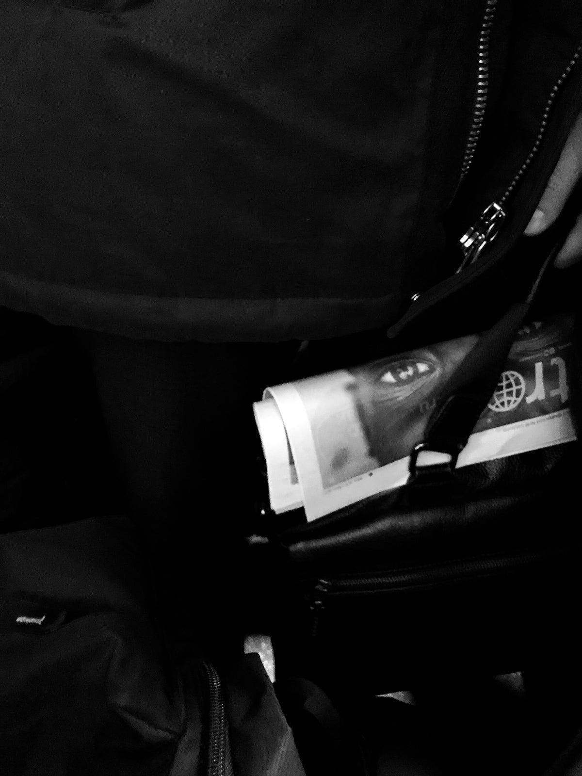 a black and white photo of a person holding a wallet