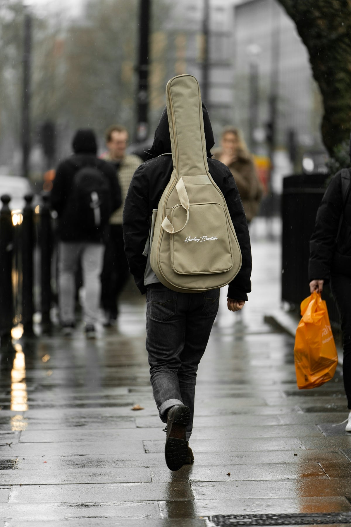 a man with a guitar case walking down the street