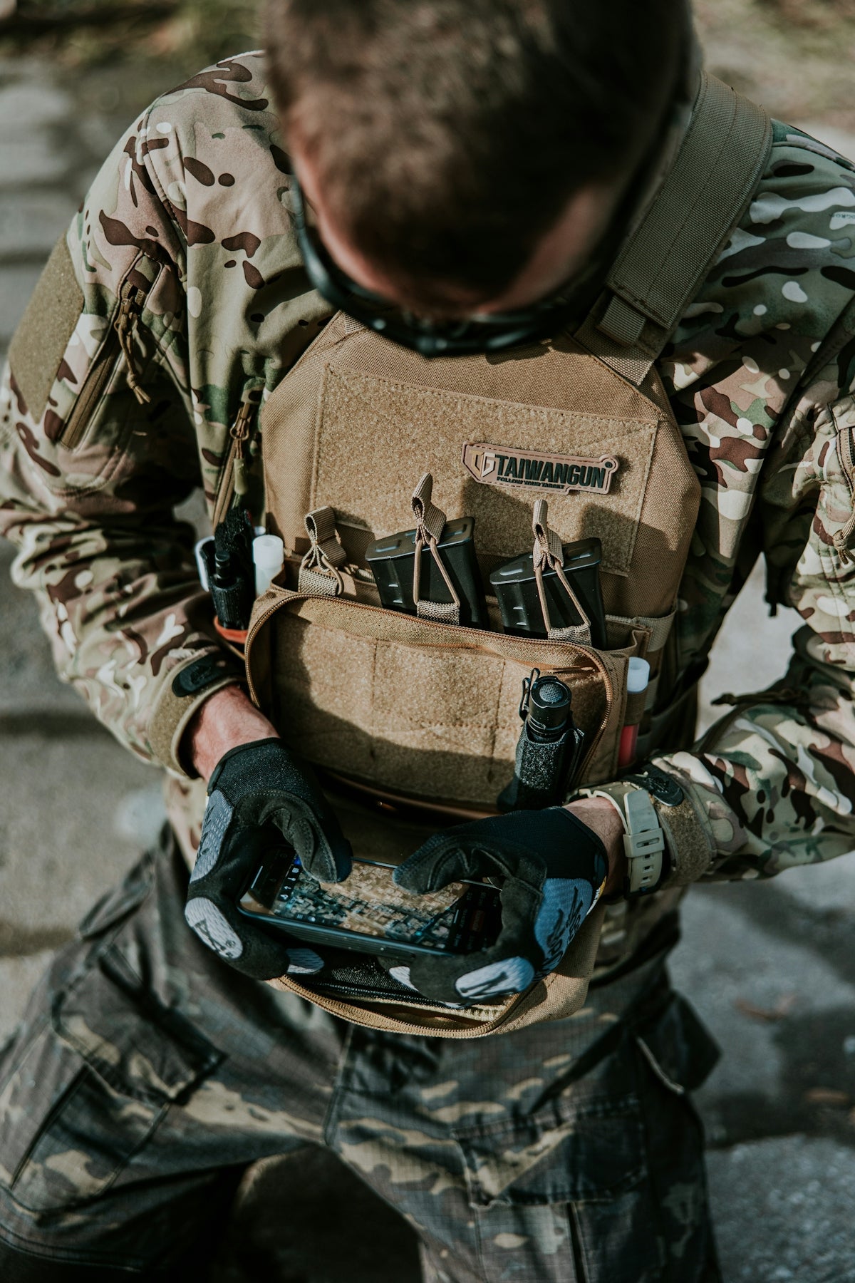 a man in camouflage holding a tool bag