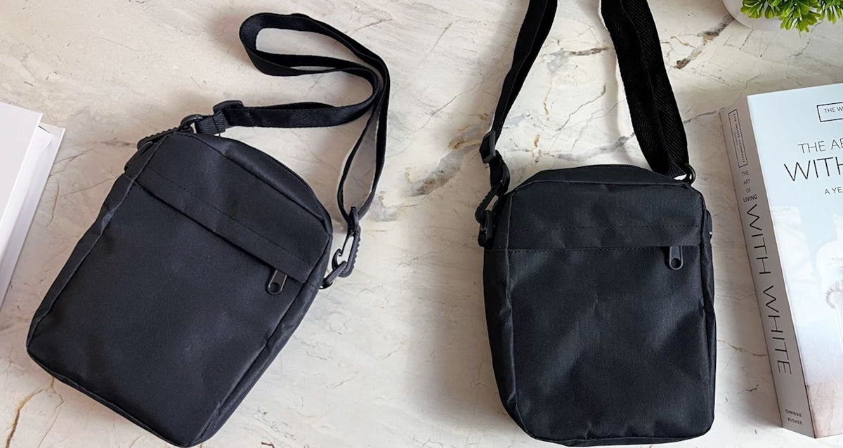 Two black messenger bags are on a light surface.